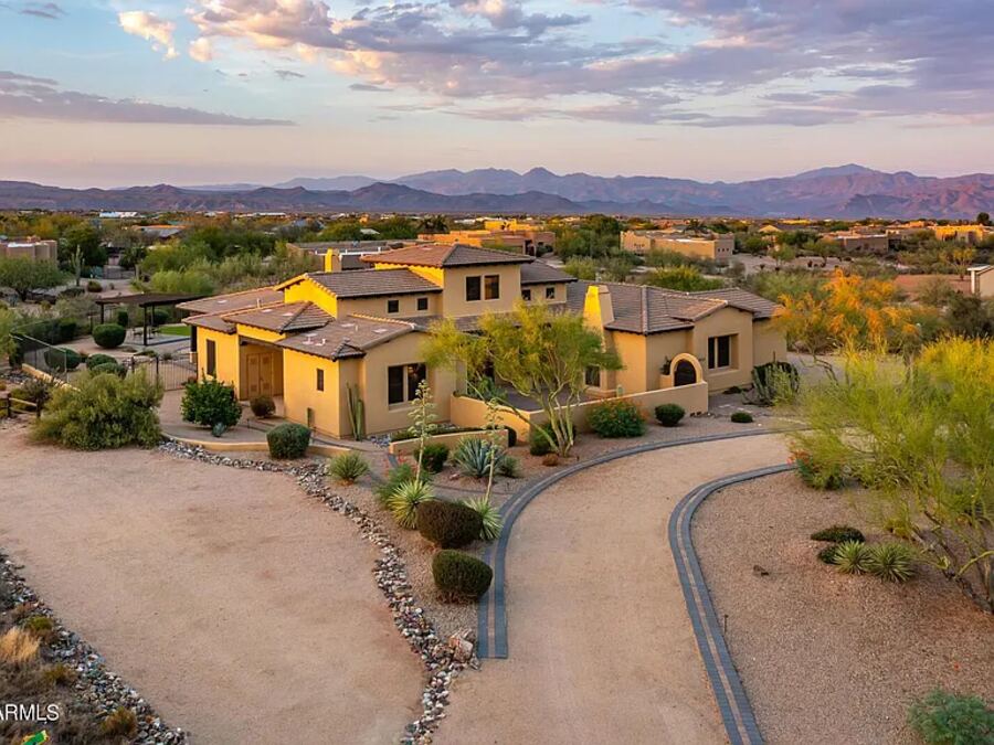 Aerial view of a Sonoran-style estate at sunset with mountain backdrop
